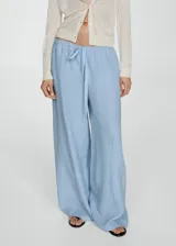Pantalon wide leg de lino, color celeste, con cintura elástica y lazo de ajuste. Presenta costuras verticales frontales y bolsillos laterales.