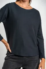 Sweater negro de tejido de punto con textura acanalada horizontal, corte holgado y mangas largas.