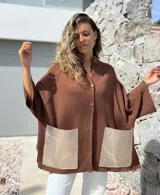 Saco tejido de punto en color marrón chocolate, con corte holgado y mangas anchas. Presenta cierre frontal con botones y dos bolsillos delanteros grandes en material metalizado color champán.