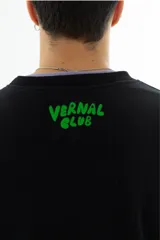 Buzo negro de algodón con cuello redondo y puños acanalados. Estampado frontal con un personaje de caricatura y el texto "HOME ALONE" en verde.