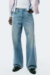 Jeans de cinco bolsillos en denim de algodón rígido, color celeste claro con efecto desgastado. Modelo de corte holgado de cadera a bajo con pierna amplia y tiro caído.