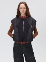 Chaleco de corte cuadrado con diseño bicolor en tonos terracota y crema. Presenta cierre frontal metalizado, parches de nylon en el pecho, interior forrado en corderito y cordón ajustable en el ruedo.