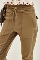 Pantalón tipo babucha de gabardina elastizada, color negro, con cintura elástica ajustable mediante cordón, puños en los tobillos, bolsillos diagonales frontales y bolsillos traseros con solapa y botón.