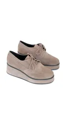 Zapatos tipo oxford con plataforma, color khaki, confeccionados en gamuza con perforaciones decorativas y puntera wingtip brogue. La plataforma es uniforme y la suela es sintética.