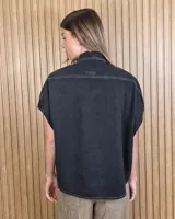 Camisa de denim liviano color azul, de mangas cortas amplias y corte oversize. Presenta cuello camisero clásico y cierre frontal con botones.