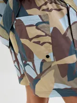Short de baño con estampado botánico abstracto en tonos tierra, azul y gris. Cuenta con cintura elástica con cordón ajustable, bolsillos laterales y un bolsillo trasero.