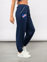 Pantalón de piqué recto color azul marino, con cintura elástica y cordón ajustable. Presenta el escudo del Club Nacional de Football en el muslo izquierdo y el logo de Umbro en el muslo derecho.