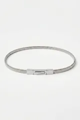 Cinturón fino de metal dorado con diseño de malla flexible y hebilla rectangular con detalle central alargado.