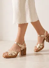 Sandalias de cuero dorado con tiras cruzadas en la parte delantera, tira ajustable con hebilla al tobillo, plataforma y taco ancho efecto madera.