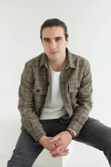 Sobrecamisa de paño marrón con diseño escocés a cuadros. Tiene cuello clásico, cierre frontal con botones, dos bolsillos de parche en el pecho y corte recto.