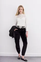 Pantalón tipo babucha confeccionado en terciopelo negro, con cintura elástica, bolsillos plaqué frontales con remaches metálicos y bolsillos cargo laterales. Presenta puños elásticos en la botamanga.