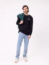 Remera de manga larga color negro con estampado gráfico blanco en la espalda, perteneciente a la marca Rusty.