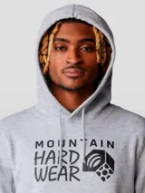 Buzo canguro gris melange con capucha y bolsillo canguro frontal. Estampado frontal con el logo de Mountain Hardwear en negro.