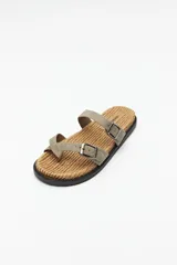 Sandalia plana negra con base de fibra trenzada y tiras cruzadas ajustables con hebillas metálicas.