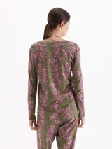 Remera de manga larga con cuello redondo, confeccionada en tejido de punto con estampado floral en tonos verdes y rosados.