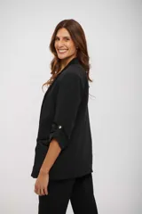 Blazer negro de corte clásico, con solapas de muesca, mangas tres cuartos con detalles de trabilla y bolsillos frontales con solapa.