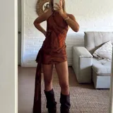 Vestido corto de microtul con diseño de doble capa y estampado abstracto en tonos marrones. Presenta escote halter y un detalle de frunce lateral con una tira larga colgante.