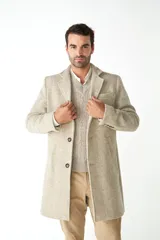 Abrigo masculino de lana color beige, con cuello con solapa, manga larga y forro interior. Tiene bolsillos laterales y cierre frontal con botones.
