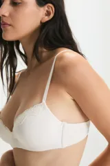 Conjunto de lencería compuesto por un corpiño con taza soft y aro, y una bombacha tipo vedetina. Ambas piezas presentan detalles de encaje en los bordes y están confeccionadas en un tejido suave y elástico.