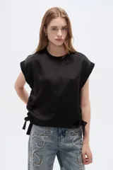 Remera negra de poliéster con cuello redondo y mangas cortas con vuelta.