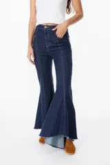 Jean elastizado azul oscuro con diseño de volados en la parte baja de la pierna, ruedo descosido con juego de largos (más largo atrás que adelante).