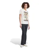 Remera de algodón beige de corte clásico, con mangas cortas y cuello redondo. Presenta un estampado frontal que combina el texto "Adidas" y "Farm Rio" en color marrón con un gran ramo de flores coloridas en el centro.