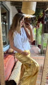 Chaleco de lino en color beige, con escote en V, cierre frontal con botones y bolsillos delanteros decorativos.