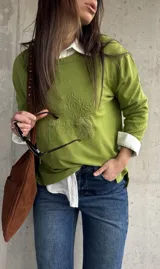 Sweater de punto color verde lima, de manga larga, con detalle de bordado en relieve con diseño floral en el frente.