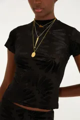 Top negro entallado de manga corta con cuello alto y textura sutil de diseño floral.