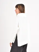 Polera de manga larga en color negro, confeccionada en tejido de punto con textura acanalada fina. Presenta un cuello alto tipo polera, corte holgado y puños ajustados.