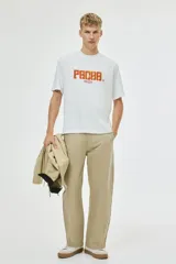 Remera de algodón color blanco con cuello redondo y mangas cortas. Presenta un estampado frontal con el logo de Pacha Ibiza en tonos naranja y amarillo.
