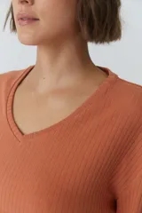 Buzo color ladrillo de punto rib con escote en V y mangas 3/4.