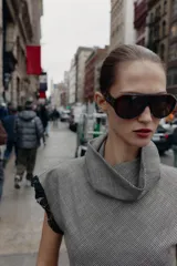 Top sin mangas con cuello subido, confeccionado en tejido con estampado pata de gallo. Presenta un diseño asimétrico en el bajo decorado con encaje negro, detalle que también se encuentra en las sisas.