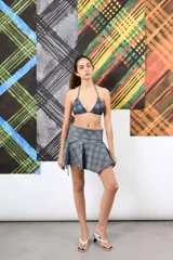 Top de bikini triangular con estampado a cuadros en tonos marrón, celeste y verde, con un aplique floral tridimensional de cuentas verdes en el tirante.