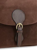 Cartera tipo bandolera de cuero gamuzado en color marrón chocolate, con solapa frontal y cierre mediante hebilla decorativa con broche a presión. Incluye correa ajustable y detalles en herrajes dorados.
