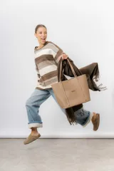 Bolso tipo tote de diseño amplio y funcional, confeccionado en material texturado con acabado mate. Presenta doble asa larga para llevar al hombro, costuras reforzadas y logo metálico aplicado en el frente.