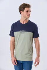 Remera de algodón y poliéster de corte clásico, con diseño en bloques de color negro en la parte superior y gris melange en la inferior. Presenta cuello redondo, mangas cortas y un pequeño estampado tipográfico en el pecho.