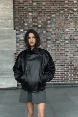 Vestido corto de corte ajustado con escote tipo bustier y tirantes finos. Presenta costuras verticales que definen la silueta y cierre posterior con cremallera oculta.