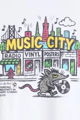 Remera blanca Levi's de corte relajado, con cuello redondo, mangas cortas y estampa frontal colorida con la leyenda 'Music City' y diseño de ciudad con un animal sosteniendo un disco de vinilo.