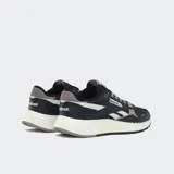 Championes Reebok Classic Leather 2400, color negro con detalles en blanco, gris y beige. Presentan el logo de Reebok en el lateral y la lengüeta, y cordones grises.