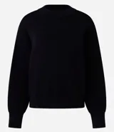 Buzo de tricot con cuello redondo y puños ajustados. Presenta un diseño de calce holgado y tejido de punto liso.