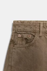 Jeans de tiro medio con corte cropped y diseño de costuras torcidas. Presenta trabillas en la cintura, cinco bolsillos clásicos y cierre frontal con cremallera y botón metálico.