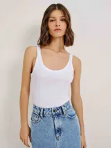 Musculosa ajustada color crema, con cuello redondo y tejido acanalado.