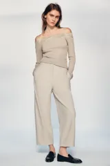 Pantalón de tiro medio con corte tipo ballon, bolsillos delanteros y detalle de pinzas. Cuenta con cierre frontal de cremallera y gancho metálico.