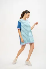 Vestido tipo remerón tejido en algodón con diseño a cuadros en tonos celeste, azul y lila.