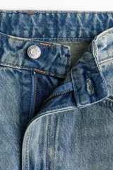 Pantalón de jean con diseño wide leg, de tiro alto y cinco bolsillos, en tono azul desgastado.