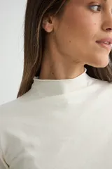 Polera de tejido de punto fino color bordó, con cuello alto y mangas largas.