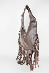 Cartera de cuero color negro, de diseño redondo tipo hobo con manija integrada y flecos largos colgantes en todo el borde inferior.