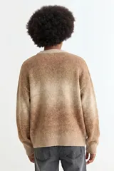 Sweater de tejido de punto con diseño degradé en tonos azules y beige, de corte holgado, cuello redondo y mangas largas.