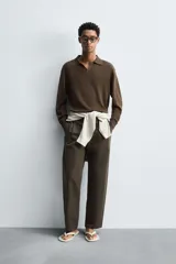 Polo de punto regular fit en color beige, confeccionado con una mezcla de algodón y cáñamo. Presenta cuello solapa con abertura frontal, manga larga y acabados en rib.